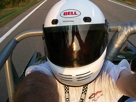 Kris in a helmet racing at the Glen